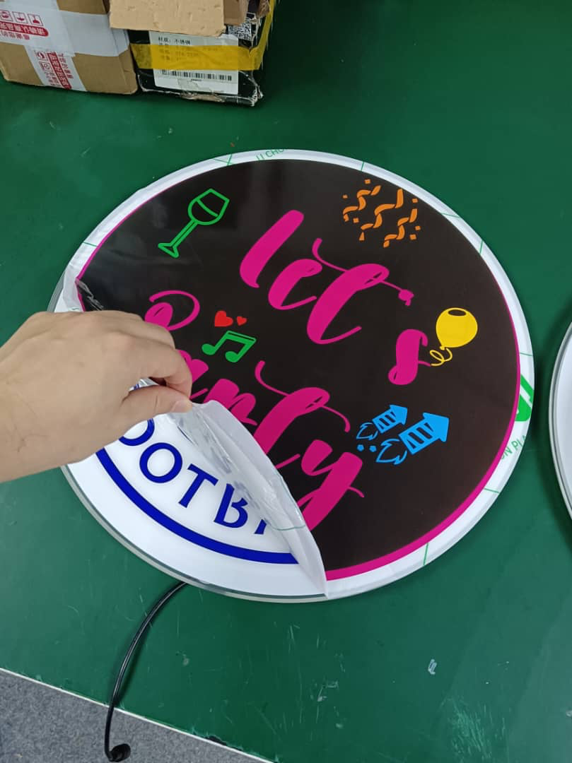 Protective 'Let's Party' sticker being peeled off to reveal the panel underneath